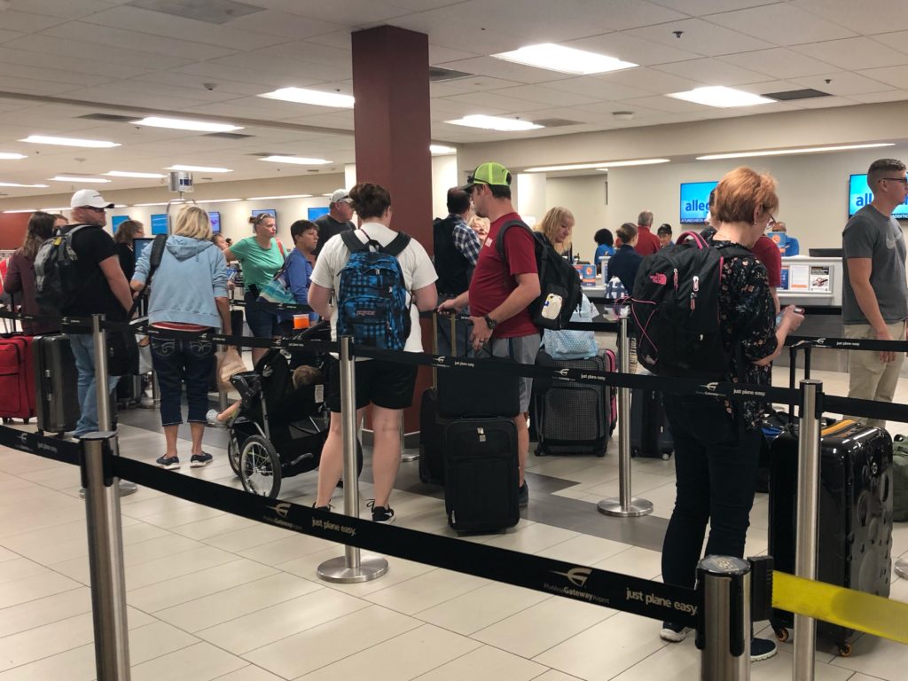 line of people waiting to check bags at airport